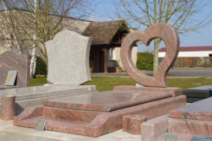 Monument funéraire en granit rose avec une stèle découpée en forme de cœur.