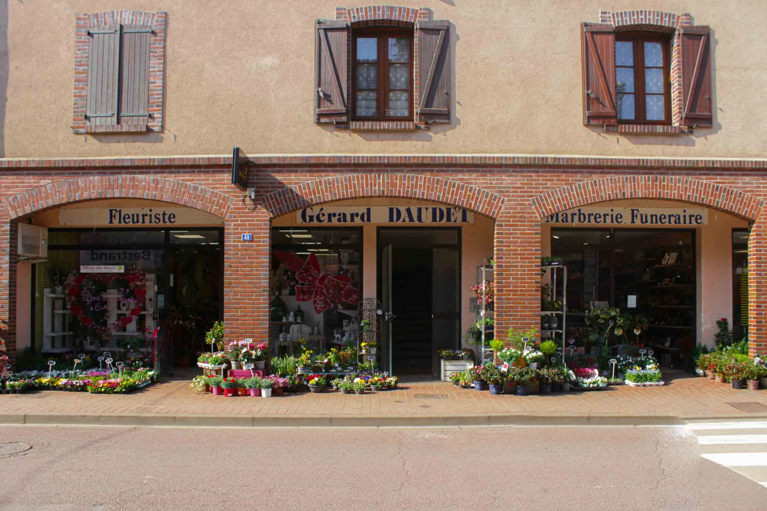 Devanture d'un magasin de marbrerie funéraire et fleuriste Gérard Daudet.